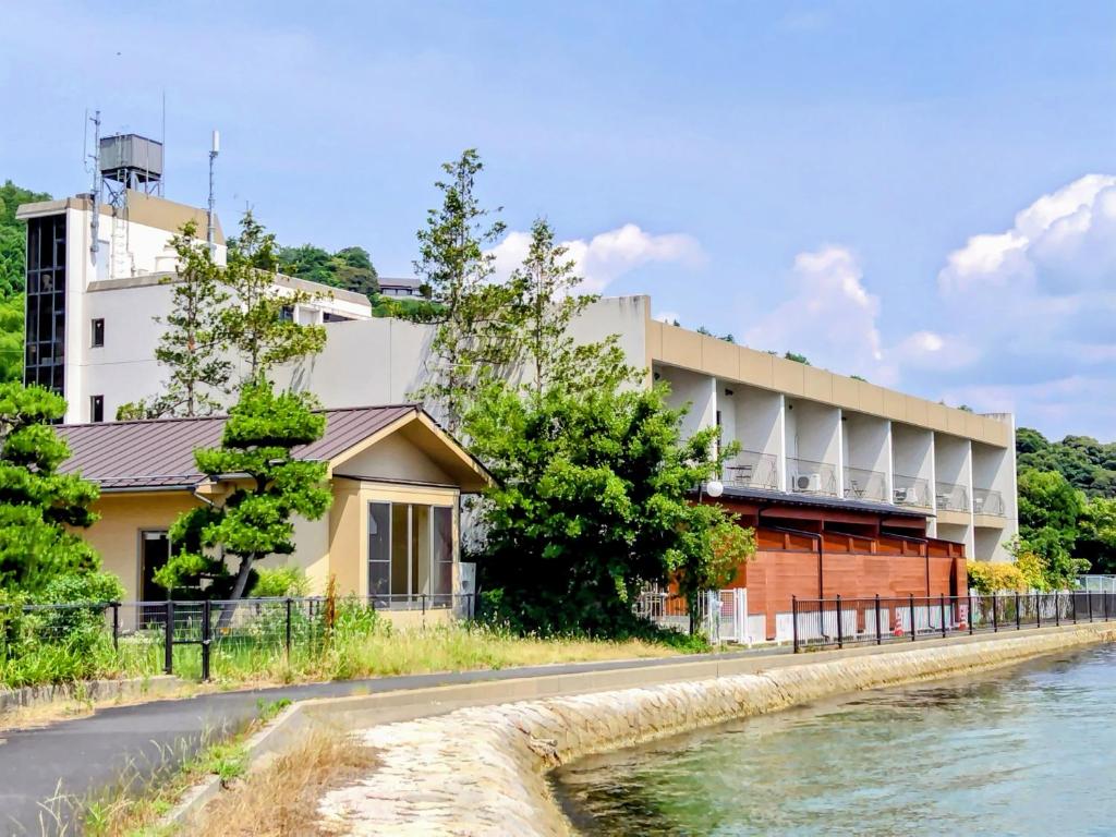 Seaside ryokan exterior Amanohashidateso Kyoto Waterfront building with seawall and trees at Amanohashidateso in Kyoto, Kansai