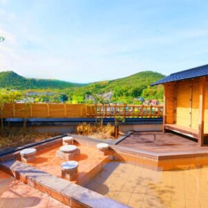 Open-air onsen bath with wooden deck and mountain views at Arimakan in Tōhoku, Yamagata