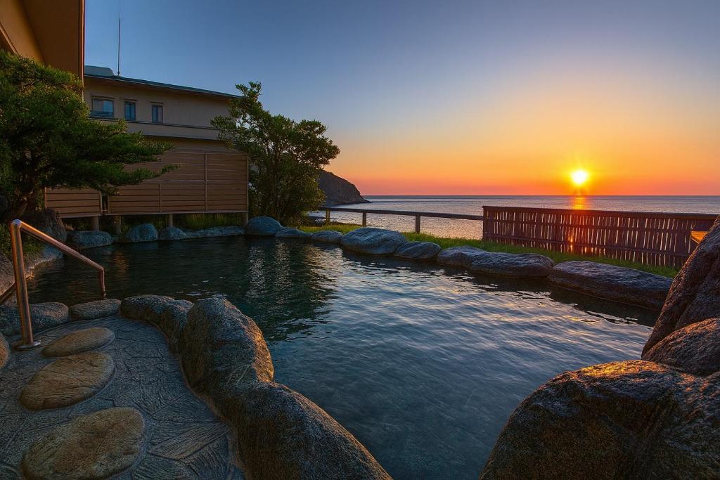 Sunset outdoor onsen at Atagawakan Shizuoka Outdoor stone onsen at sunset overlooking the sea, Atagawakan, Shizuoka