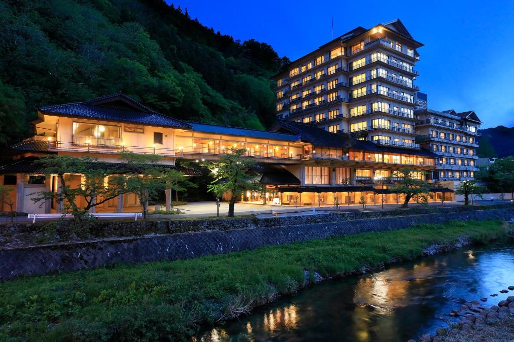 Riverside ryokan exterior Bankokuya Tohoku Yamagata Lit riverside ryokan building by mountain stream Bankokuya Tohoku Yamagata Japan