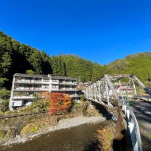 Bridge over river with Bijintei ryokan beside forested hills in Wakayama Kansai
