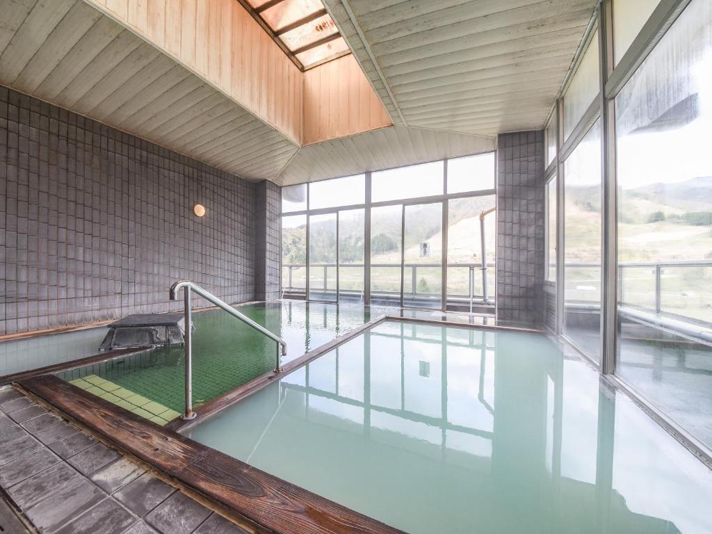 Indoor Onsen Bath at Bousenkaku, Niigata Milky onsen pools inside tiled bathhouse with large windows overlooking grassy hills at Bousenkaku Niigata