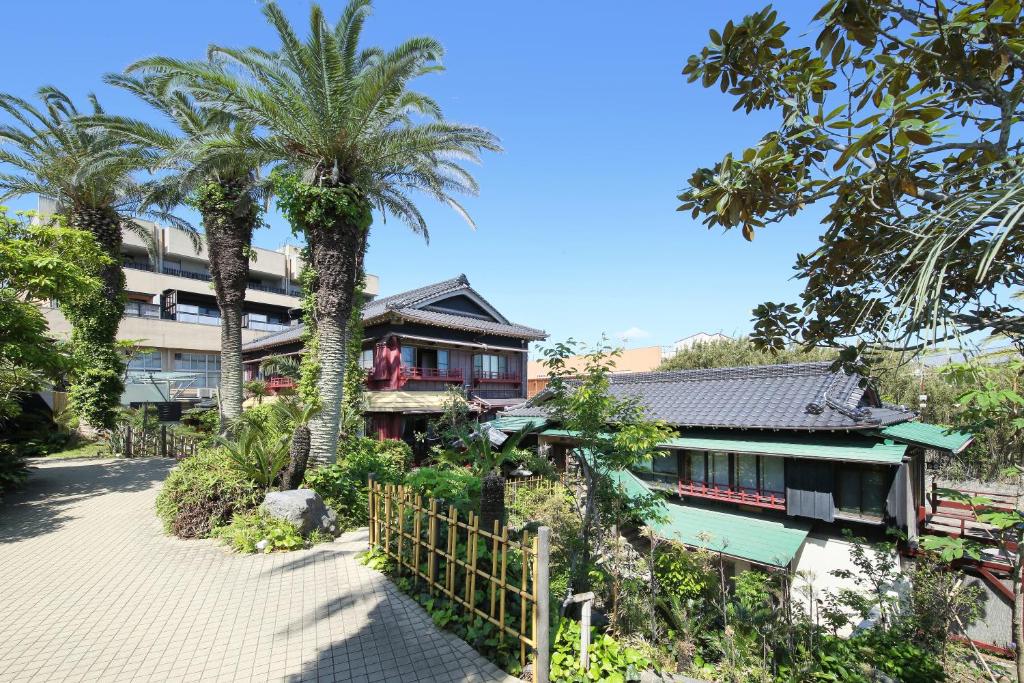Palm-lined approach at Chikurakan Chiba Palm trees and tiled ryokan buildings at Chikurakan in Chiba, Kanto with paved garden path and greenery