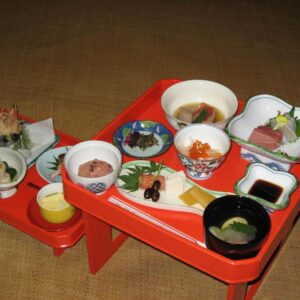 Red lacquer trays with assorted small dishes on tatami at Gyokuzoin in Nara