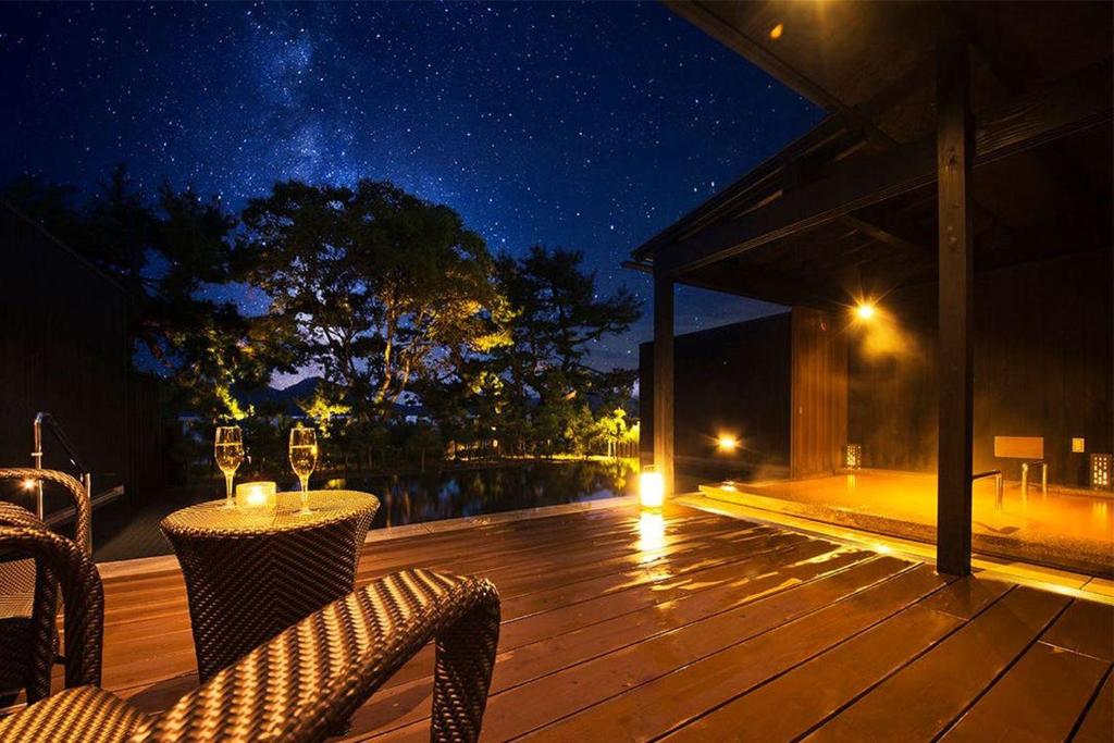 Starry Onsen Deck HOSHINO-OTO Kyoto Wooden outdoor onsen deck with lounge chairs under a starry sky at HOSHINO-OTO in Kyoto