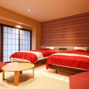 Twin tatami room with shoji screens, low table and red bedding at Hanamandara in Hyōgo, Kansai