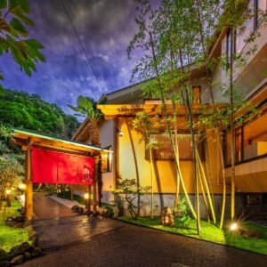 Red noren at entrance with bamboo garden, stone path and lanterns at Hanashibuki in Chiba