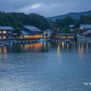 Evening lights reflecting on lake in front of Hiogiso ryokan in Mie, Kansai with wooden waterfront buildings