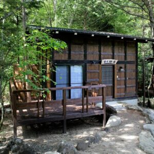 Wooden guest cabin with deck among trees at Hirayunomori in Chūbu, Gifu, Japan