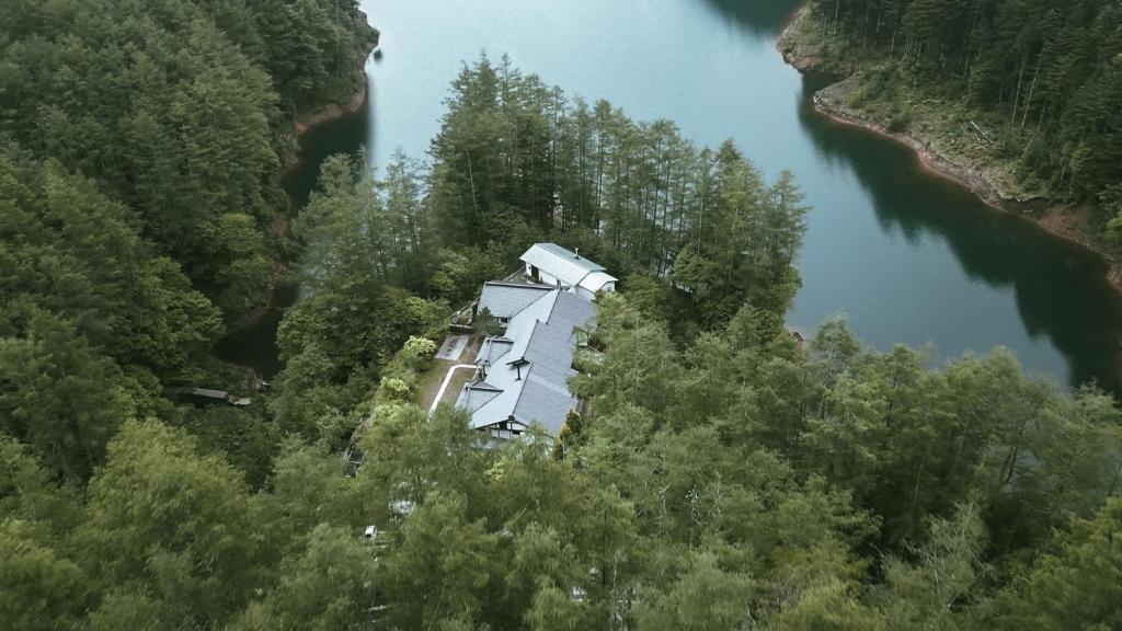 Aerial lakeside ryokan Hotorinite Yamanashi Aerial view of Hotorinite among dense forest on a lakeshore in Yamanashi, Chūbu