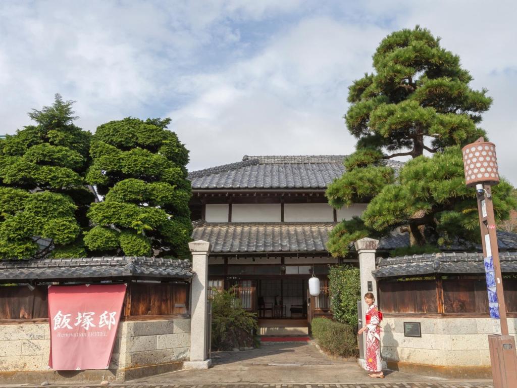 Traditional ryokan entrance Iizukatei Tochigi Ryokan entrance with tiled roof, noren and kimono-clad guest at Iizukatei, Tochigi
