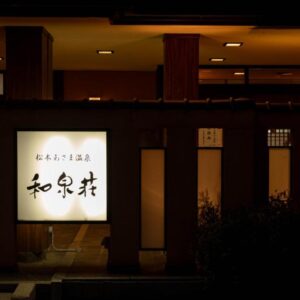 Warm-lit entrance and glowing sign at Izumiso ryokan in Nagano, Chūbu, Japan