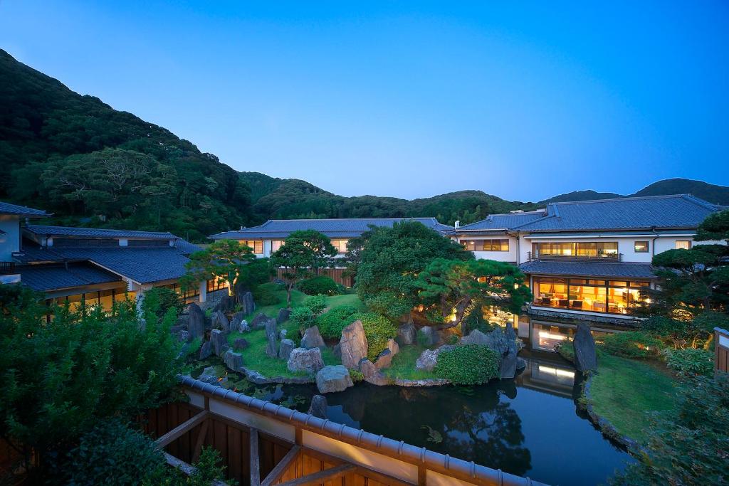 Dusk garden at Kagetsutei Shizuoka Chūbu Japan Lit garden pond and traditional buildings at Kagetsutei with mountain backdrop in Shizuoka Chūbu
