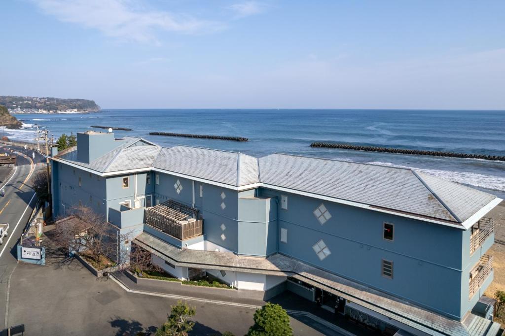 Seaside ryokan exterior Kaiyutei Shizuoka Japan Blue coastal ryokan building Kaiyutei along Shizuoka coastline with road and parking area