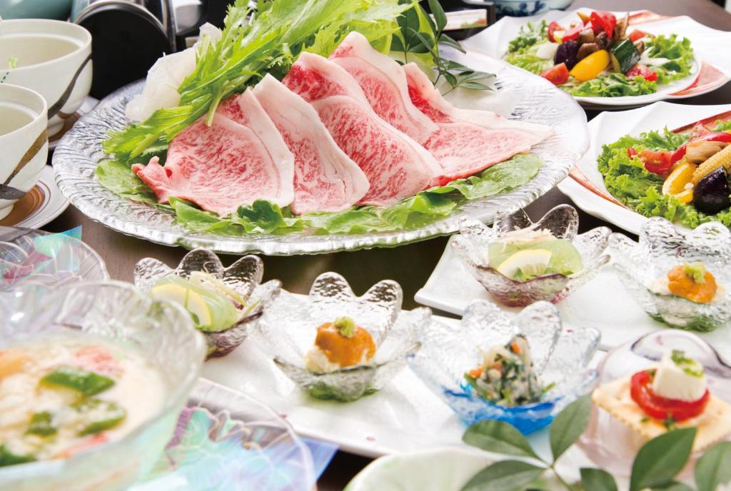 Multi-course Japanese meal Kakureisen Saga Kyushu Assorted small dishes and thinly sliced meat served on a table at Kakureisen ryokan in Saga, Kyushu, Japan
