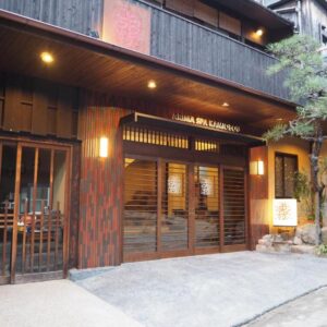 Entrance of Kamiobo Ryokan in Hyōgo with wooden facade, sliding doors and stone lantern