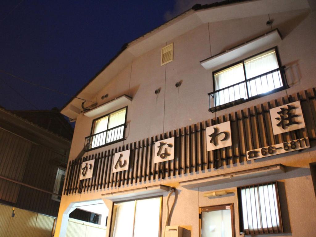 Evening exterior of Kannawaso in Ōita Exterior facade of Kannawaso with lit windows and Japanese signage at night in Ōita, Kyūshū