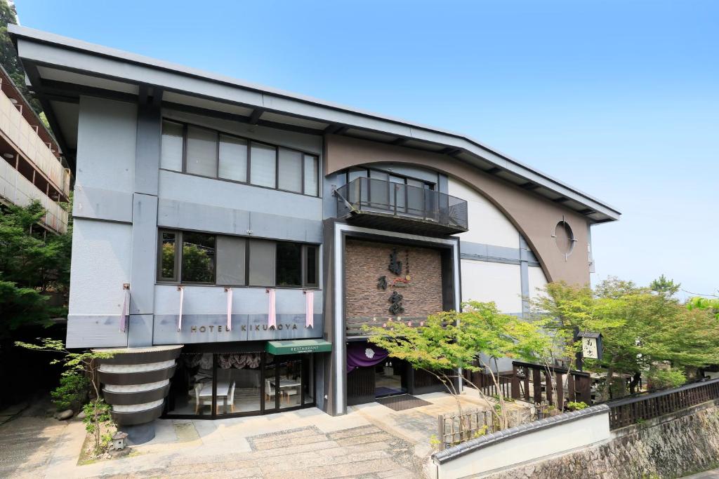 Ryokan exterior Kikunoya Hiroshima Front facade and entrance of Kikunoya with balconies and landscaped trees in Hiroshima, Chūgoku region