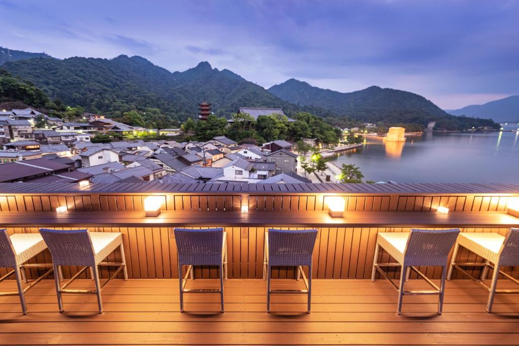 Terrace overlooking bay at Kinsuikan Hiroshima Wooden deck with chairs at Kinsuikan overlooking illuminated waterfront and mountains in Hiroshima, Chūgoku
