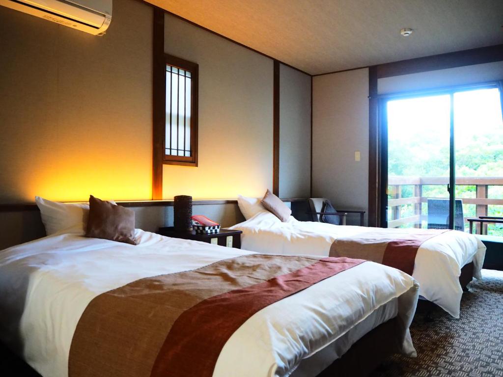 Twin Room with Balcony Kisara Mie Twin beds, bedside lamps and seating area by a sliding glass door to balcony at Kisara in Mie