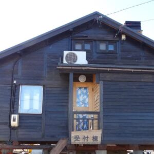 Dark wooden ryokan exterior with entrance steps and sign at Koinami in Mie, Kansai, Japan