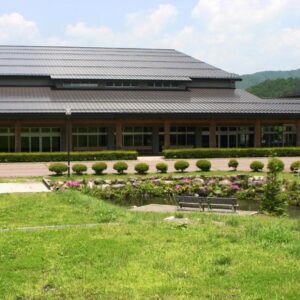 Low-rise building with lawn and pond at Komao ryokan in Chubu, Nagano