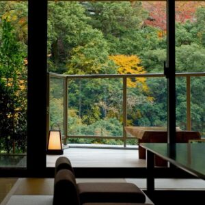 Tatami seating with low table and large windows framing tree-covered garden at Koorogirou, Ishikawa