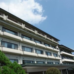 Multi-story ryokan building with balconies and pine trees at Kounkaku in Fukushima Tohoku