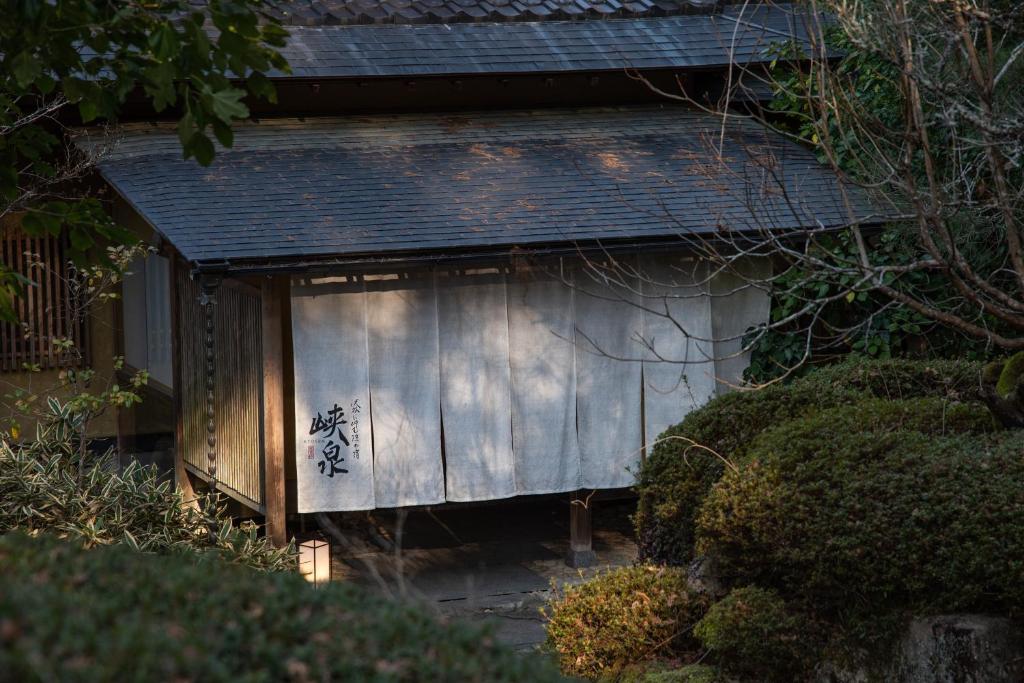 Traditional Entrance Noren at Kyousen Nagano White noren curtain with kanji at Kyousen entrance surrounded by moss and trees in Nagano