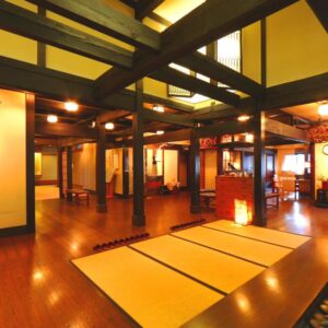 Warm wooden lobby with tatami mats and exposed beams at Matsunoi ryokan in Gifu, Chūbu