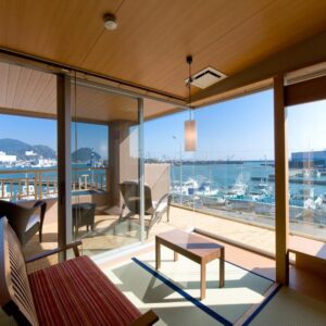 Bright tatami room with low table, balcony and marina views in Shizuoka's Chūbu region