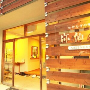 Warm-lit wooden facade and open entrance with slippers inside at Misenkan ryokan in Nara, Kansai