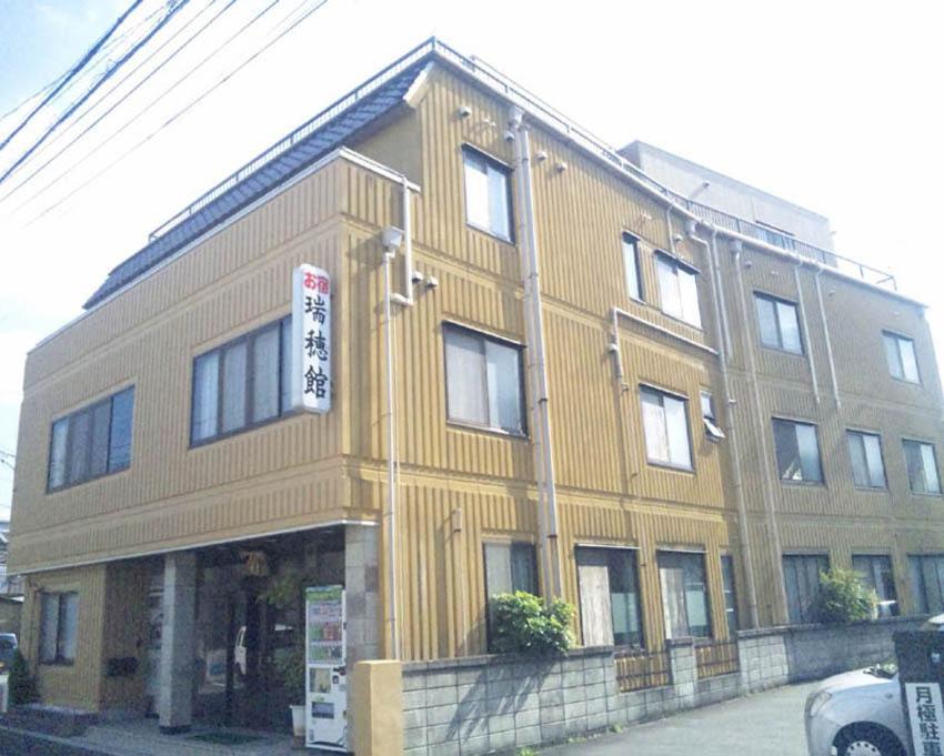 Exterior of Mizuhokan Ryokan Mie Street-facing beige exterior of Mizuhokan ryokan in Mie prefecture, Kansai region
