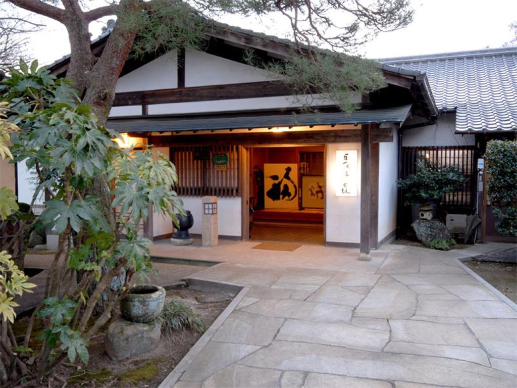 Traditional entrance Nagataki Ryokan Chubu Gifu Stone path leading to Nagataki entrance with wooden beams, lantern and garden plants in Gifu
