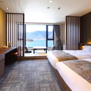 Bright twin bedroom with large window overlooking mountains and lake at Rakuyu in Chūbu, Yamanashi