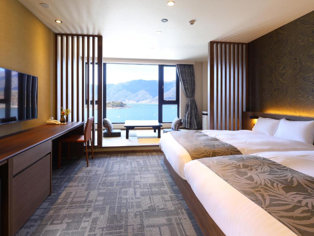 Twin room mountain view Rakuyu Chūbu Yamanashi Bright twin bedroom with large window overlooking mountains and lake at Rakuyu in Chūbu, Yamanashi
