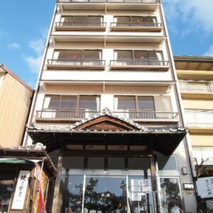 Multi-story ryokan entrance with wooden detailing at Sakuraya, Chūgoku, Hiroshima, Japan