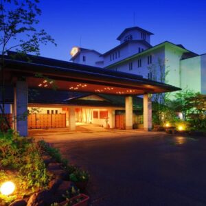 Lit entrance canopy and lanterns at Sansatei in Miyagi Tohoku, showing driveway and illuminated facade at dusk