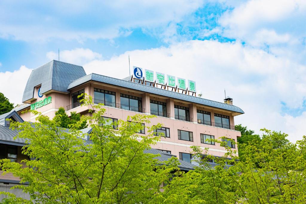 Ryokan exterior Seiryukaku Iwate Japan Multi story Seiryukaku building facade framed by green trees under blue sky in Iwate Tohoku