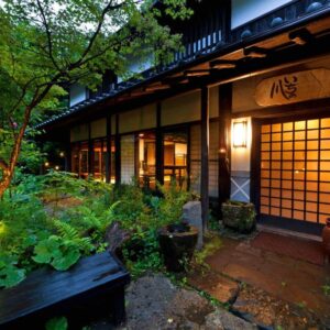 Evening lit shoji entrance with stone path and verdant garden at Sen-no-Mori in Kumamoto, Kyushu