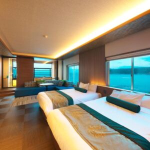 Spacious triple room with three beds, seating area and large windows overlooking coastal waters in Shizuoka