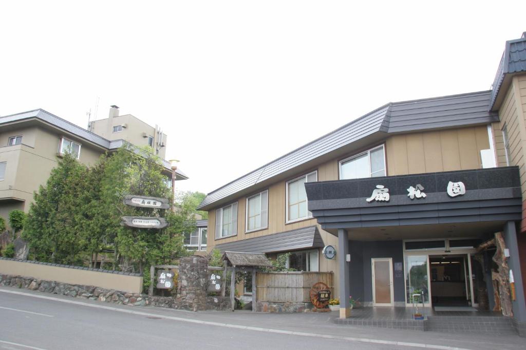 Ryokan exterior Senshoen Hokkaidō Japan Entrance and facade of Senshoen ryokan on a quiet Hokkaidō street with greenery and neighboring buildings