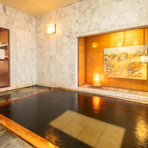 Wood-framed indoor bath with marble walls and warm lighting at Shimaya, Nagano, Chūbu