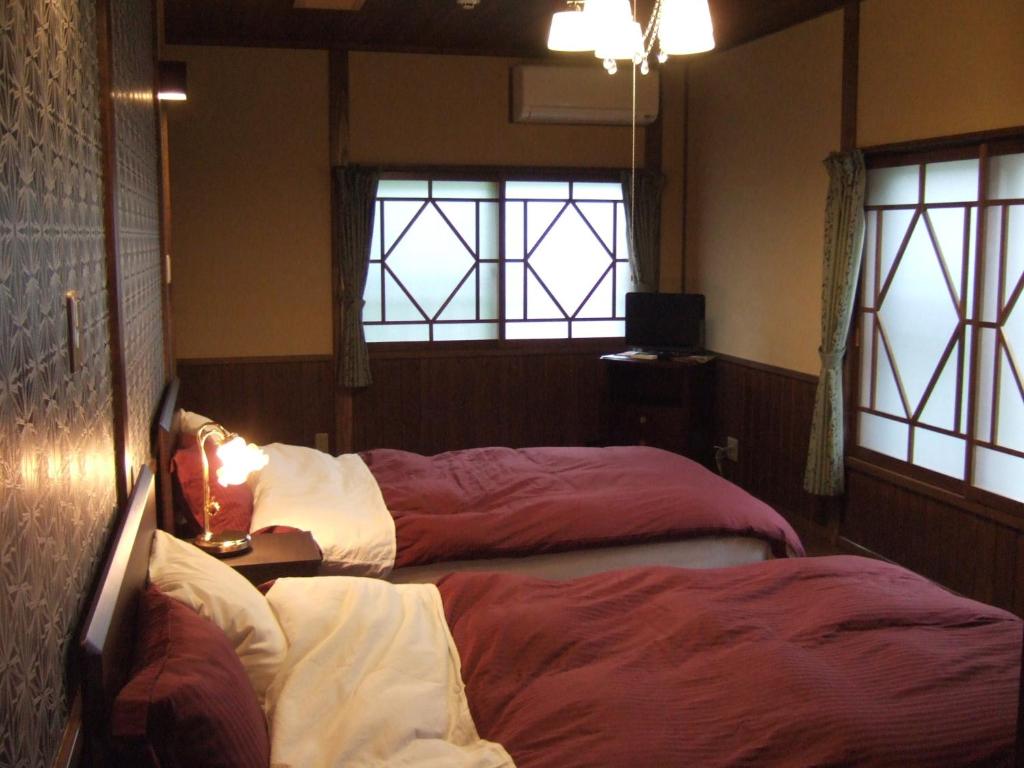 Twin Bedroom at Shinseikan Iwate Two twin beds, wooden walls, shoji windows and a small TV in a Shinseikan room, Iwate prefecture