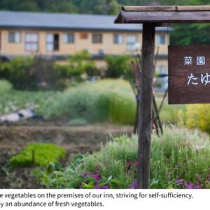 Wooden entrance sign beside a garden path with ryokan buildings in the background, Shizukatei, Iwate