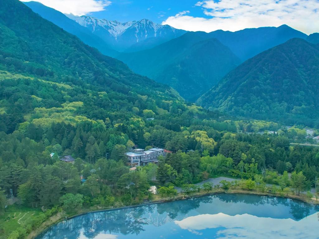 Mountain lake setting Suzuranso ryokan Nagano Lakeside ryokan nestled in forest with distant mountain peaks, Suzuranso Nagano