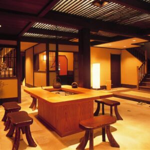 Traditional wooden reception area with central table, stools, shoji screens and warm ambient lighting at Taikyourou, Kyoto