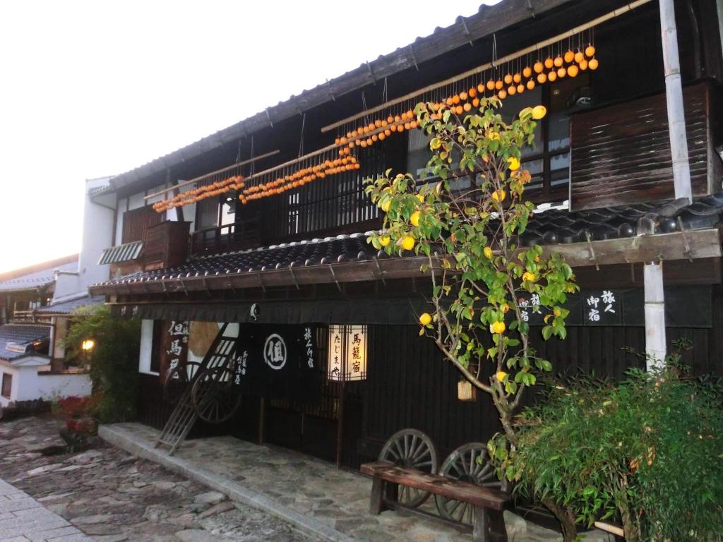 Wooden ryokan facade Tajimaya Chūbu Gifu Japan Two-story traditional wooden ryokan entrance with hanging lanterns, noren curtain and stone path in Gifu