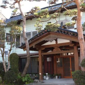Wooden entrance with pine trees at Tamonkan in Yamagata