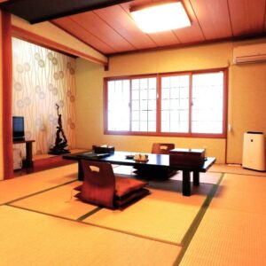 Tatami room with low table, floor chairs and shoji screens at Tenryuso in Chiba, Kantō, Japan